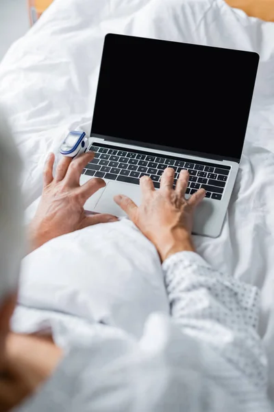 Homályos Beteg Pulzoximéterrel Laptoppal Üres Képernyővel Ágyon — Stock Fotó