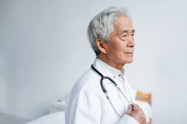 Medico Asiatico Con Stetoscopio Guardando Altrove Clinica — Foto Stock