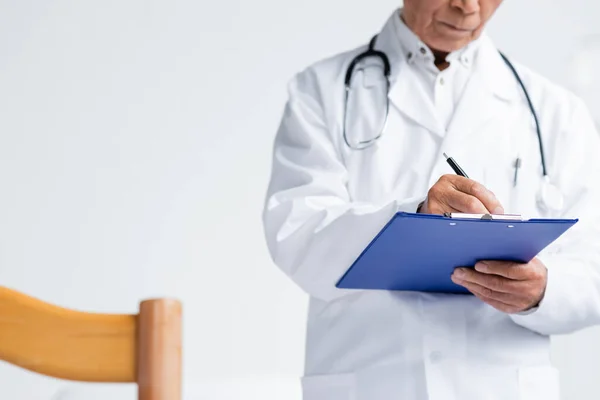 Vista Recortada Del Doctor Borroso Escribiendo Portapapeles Sala Hospital — Foto de Stock