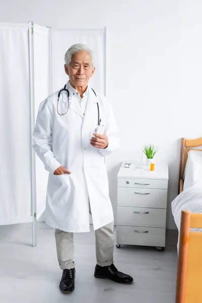 Senior Asiatico Medico Holding Smartphone Vicino Letto Ospedale Reparto — Foto Stock