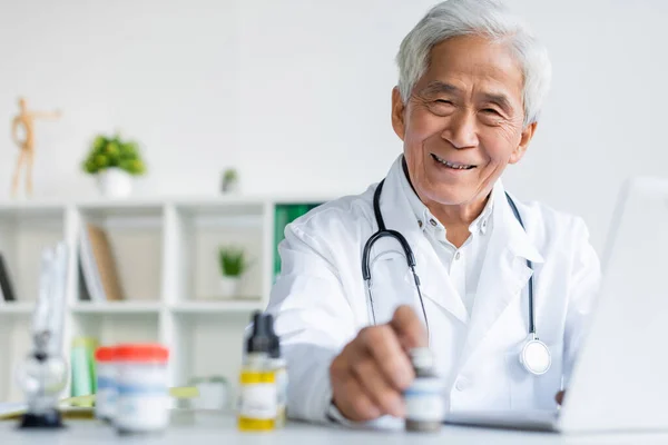 Sonriente Médico Asiático Mirando Cámara Cerca Cannabis Medicinal Portátil Clínica —  Fotos de Stock