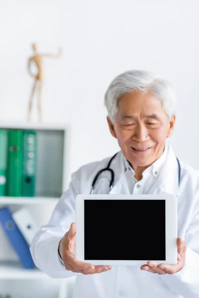 Pozytywny Azjatycki Lekarz Trzymający Cyfrową Tabletkę Ślepym Ekranem Szpitalu — Zdjęcie stockowe