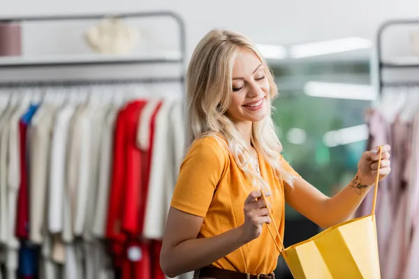 Szczęśliwa Kobieta Patrząc Żółty Torba Zakupy Butiku Odzieży — Zdjęcie stockowe