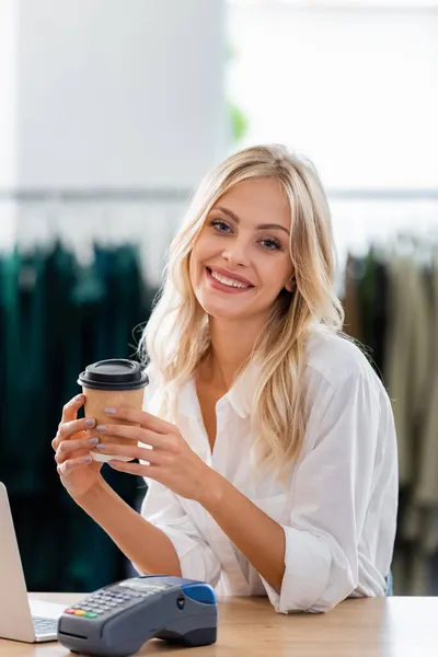 Glad Säljare Som Håller Pappersmugg Nära Betalterminalen Och Laptop Vid — Stockfoto