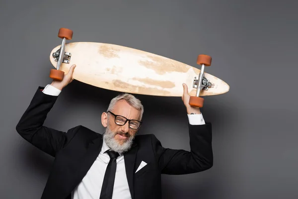 Uomo Affari Gioioso Maturo Abito Occhiali Tenendo Longboard Sopra Testa — Foto Stock