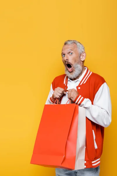 Sorprendido Hombre Mediana Edad Chaqueta Bombardero Sosteniendo Bolsas Compras Aisladas —  Fotos de Stock