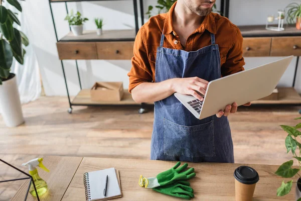 Cropped View Florist Apron Using Laptop Gloves Sprayer Notebook Flower — Stock Photo, Image