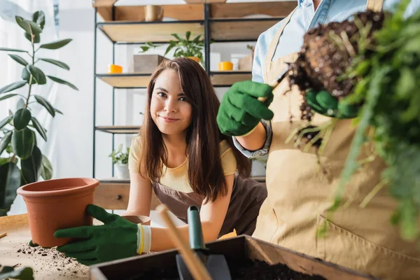 Florista Sorridente Olhando Para Câmera Perto Vaso Colega Borrado Com — Fotografia de Stock