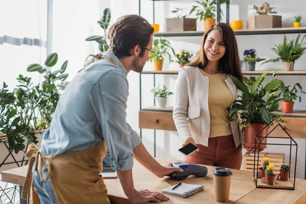 Cheerful Customer Holding Plant Paying Smartphone Seller Flower Shop — Stock Photo, Image