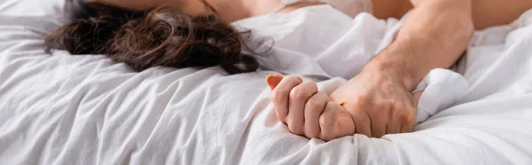 Обрізаний Вид Чоловіка Тримає Руку Розмитої Жінки Лежить Білому Ліжку — стокове фото