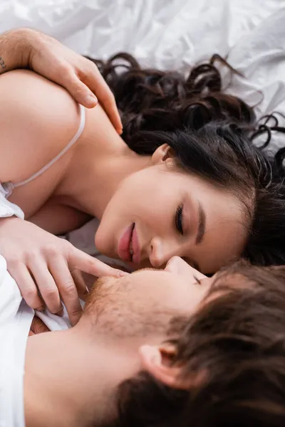 Kapalı Gözlü Tutkulu Kadın Yatakta Bulanık Adamın Dudaklarına Dokunuyor — Stok fotoğraf