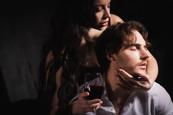 Apasionada Morena Sosteniendo Copa Vino Tinto Mientras Abraza Cuello Hombre — Foto de Stock