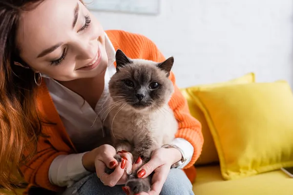Joven Mujer Sonriendo Mientras Sentado Con Gato Sofá Casa —  Fotos de Stock