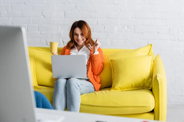 Wanita Bersemangat Dengan Secangkir Teh Bekerja Laptop Sambil Duduk Sofa — Stok Foto