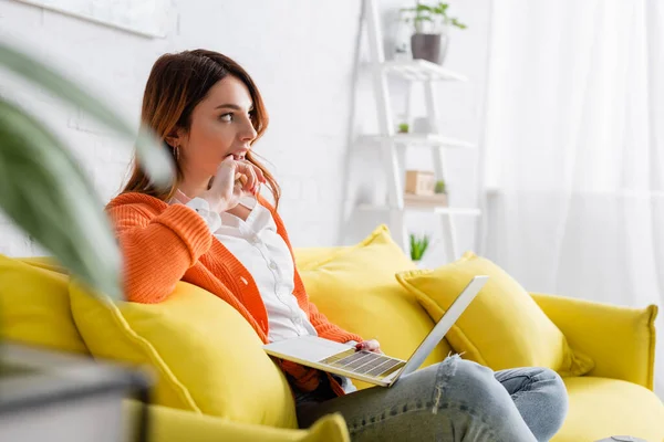 Thoughtful Freelancer Looking Away While Sitting Yellow Couch Laptop — Stock Photo, Image
