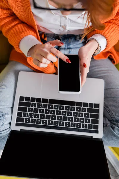 Bovenaanzicht Van Bijgesneden Vrouw Met Behulp Van Smartphone Buurt Laptop — Stockfoto