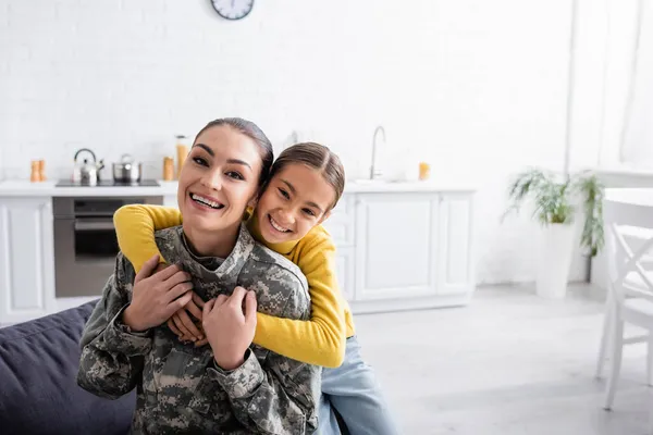 Χαμογελαστό Παιδί Αγκαλιάζει Μητέρα Στρατιωτική Στολή Στο Σπίτι — Φωτογραφία Αρχείου