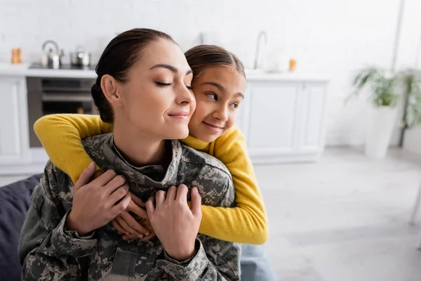 Girl Hugging Mother Military Uniform Closed Eyes Home — Stock Photo, Image