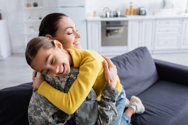 Sorridente Donna Uniforme Militare Occhi Chiusura Mentre Abbraccia Figlia Casa — Foto Stock