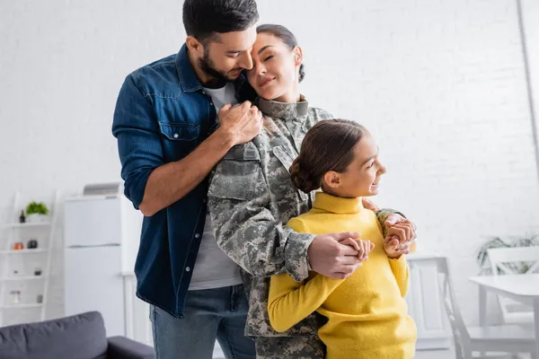 Sonriente Niño Cogido Mano Madre Uniforme Militar Cerca Papá Casa — Foto de Stock