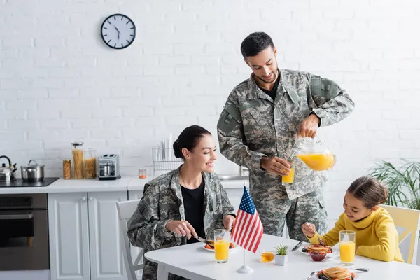 Hombre Uniforme Militar Vertiendo Jugo Naranja Cerca Familia Bandera Americana — Foto de Stock