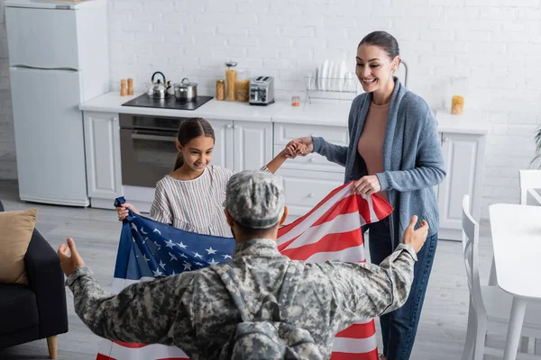 Sonriente Familia Sosteniendo Bandera Americana Cerca Soldado Casa — Foto de Stock