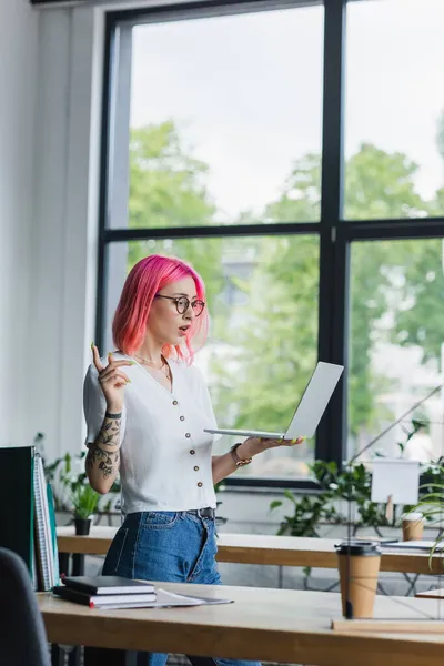 Fröhliche Junge Geschäftsfrau Mit Pinkfarbenen Haaren Mit Laptop Während Eines — Stockfoto