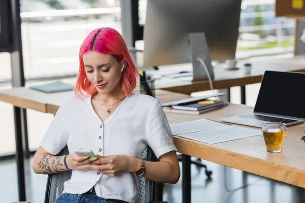 Lächelnde Junge Geschäftsfrau Mit Pinkfarbenen Haaren Und Kopfhörer Smartphone Büro — Stockfoto