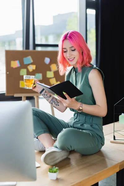 Mujer Negocios Feliz Con Pelo Rosa Sosteniendo Taza Mirando Cuaderno —  Fotos de Stock