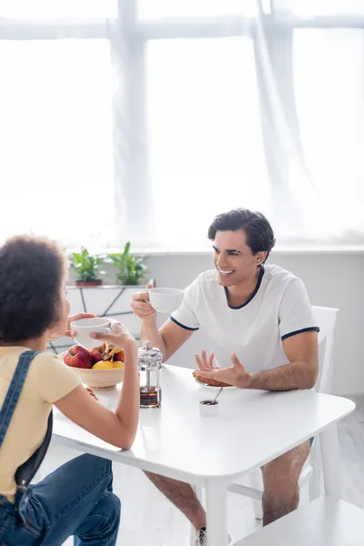 快乐的跨种族夫妇在早晨喝茶时聊天 — 图库照片