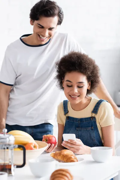 Gelukkig Interraciaal Paar Zoek Naar Smartphone Tijdens Het Ontbijt — Stockfoto