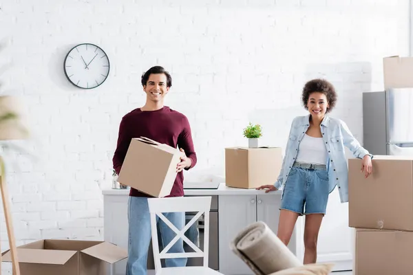 Gelukkig Man Holding Kartonnen Doos Buurt Van Afrikaanse Amerikaanse Vrouw — Stockfoto