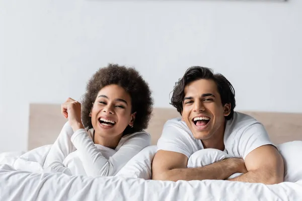 Glada Multietniskt Par Skrattar När Ligger Sängen — Stockfoto
