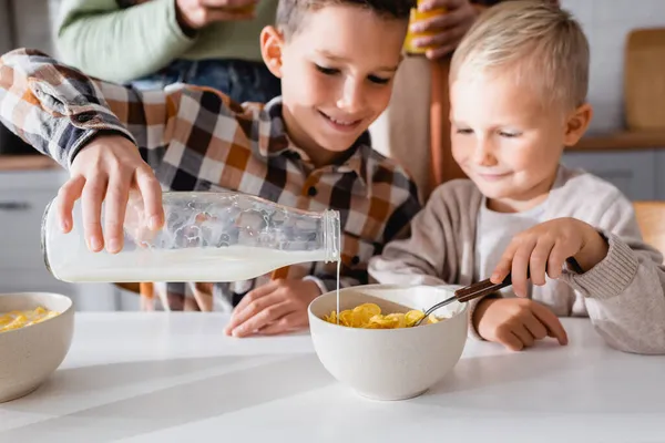Criança Derramando Leite Tigela Com Saborosos Flocos Milho Enquanto Toma — Fotografia de Stock