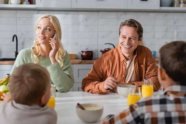 Glimlachende Vrouw Ontbijten Met Familie Tijdens Gesprek Smartphone — Stockfoto