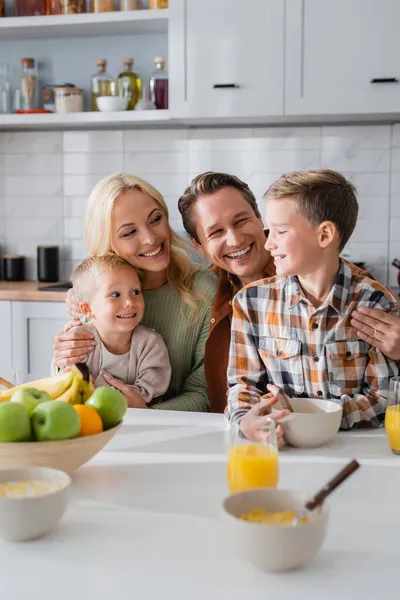 Glada Föräldrar Omfamnar Barnen Samtidigt Som Äter Frukost Köket — Stockfoto