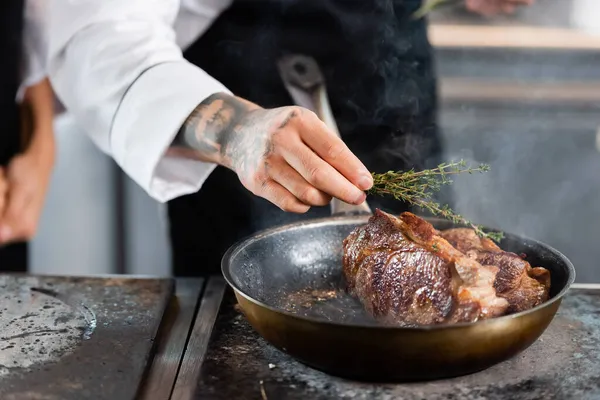 Cropped View Tattooed Chef Holding Rosemary Roasted Meat Frying Pan — Stock Photo, Image