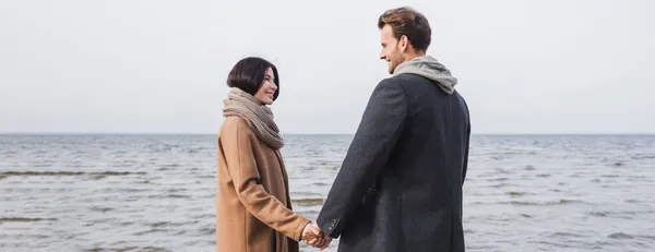 Pleased Couple Autumn Coats Holding Hands Looking Each Other While — Stock Photo, Image