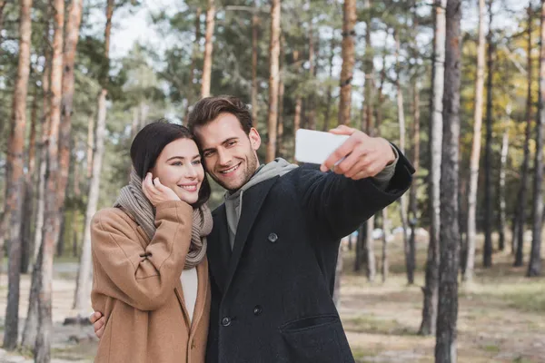 Joven Tomando Selfie Con Novia Sonriente Mientras Camina Parque Otoño — Foto de Stock