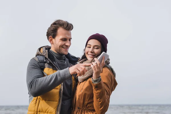 Smiling Man Pointing Smartphone Hands Girlfriend Walk River — Stock Photo, Image