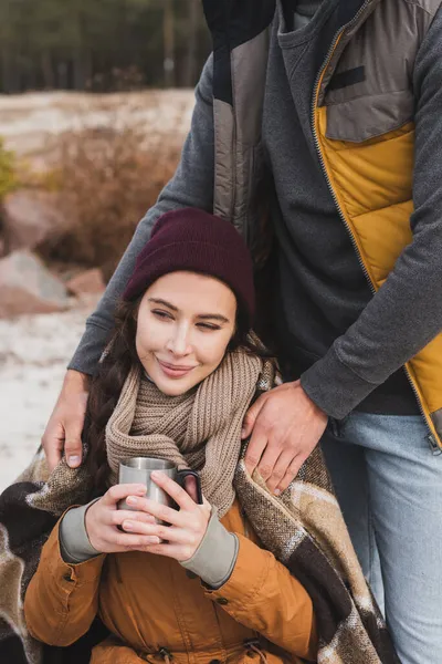 Leende Kvinna Håller Termo Kopp Nära Man Täcker Henne Med — Stockfoto