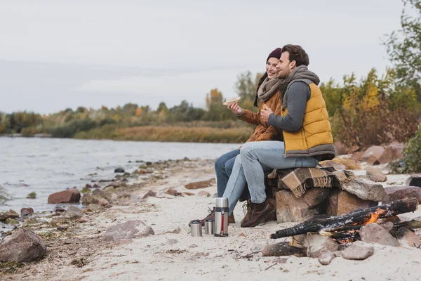 Happy Couple Autumn Clothes Looking River While Sitting Sandwiches — Stock Photo, Image
