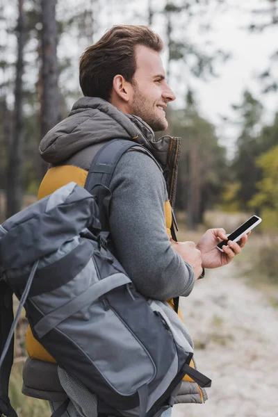 Веселий Чоловік Рюкзаком Мобільним Телефоном Тримає Мобільний Телефон Дивлячись Лісі — стокове фото