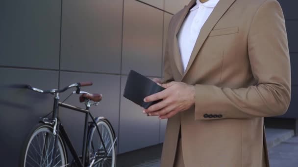 穿着西服的人把钱和纸袋拿到自行车边的景象被剪下来了 — 图库视频影像