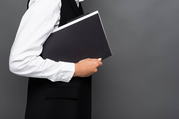 Cropped view of businesswoman holding paper folder isolated on grey 