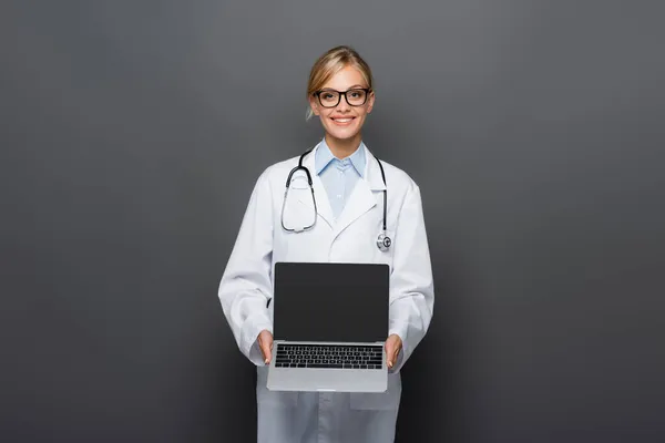 Positive Doctor White Coat Showing Laptop Blank Screen Isolated Grey — Stock Photo, Image