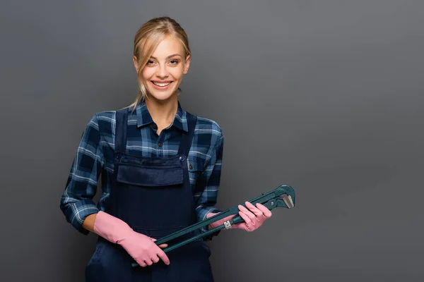 Fontanero Positivo Overoles Sosteniendo Llave Tubo Sonriendo Cámara Aislada Gris — Foto de Stock