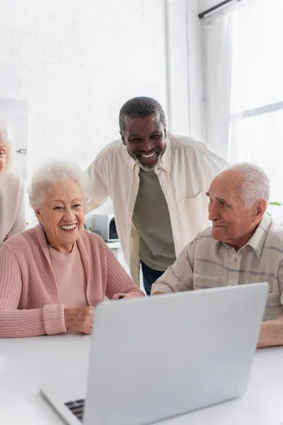 Glückliche Multiethnische Freunde Blicken Auf Verschwommenen Laptop Pflegeheim — Stockfoto