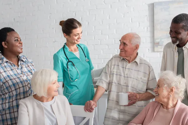 Pacientes Multiétnicos Positivos Pie Cerca Una Joven Enfermera Asilo Ancianos — Foto de Stock