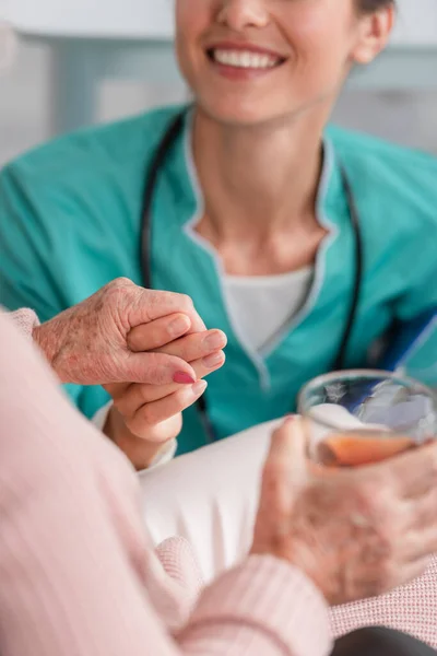 Huzurevinde Kıdemli Bir Hastanın Elini Çay Içerken Gülümseyen Hemşire Görüntüsü — Stok fotoğraf